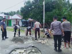 Personel Polsek Dampal Utara Tambal Jalan Trans Sulawesi yang Berlubang